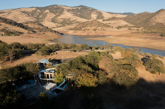 Aerial of an abandoned water park in a dry mountains with reservoir
