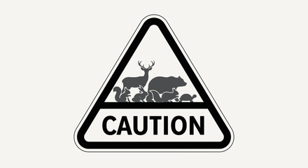 Obraz premium A white sign features a black triangle with animals above “CAUTION”
