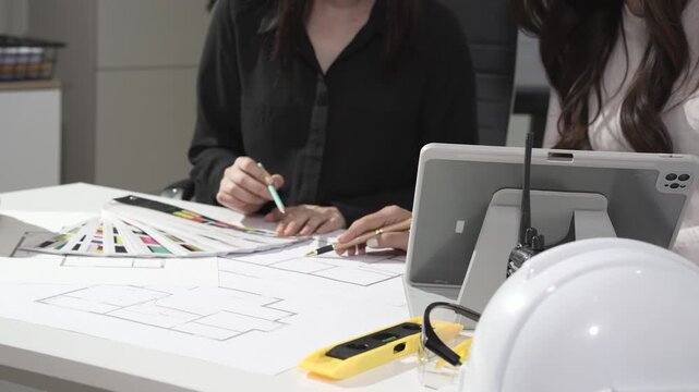 Design team reviewing floor plans and color swatches in office
