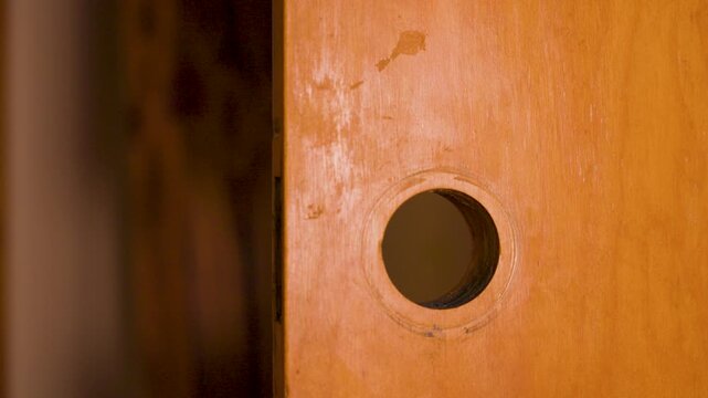 Using a drill to ream the hole for a larger door handle.