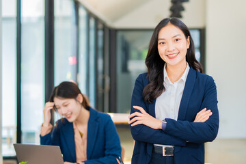 Obraz premium Smiling and elegant Asian businesswoman in business suit and office work.