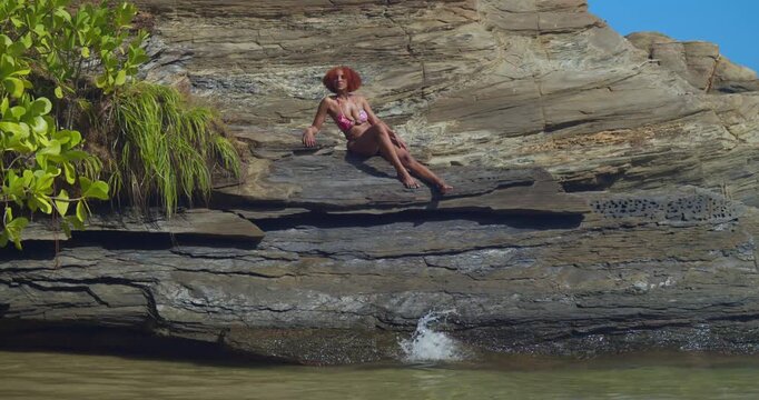 The soft sound of rhythmic waves provides the soundtrack for a girl in a bright bikini enjoying a peaceful morning on a pristine tropical beach.