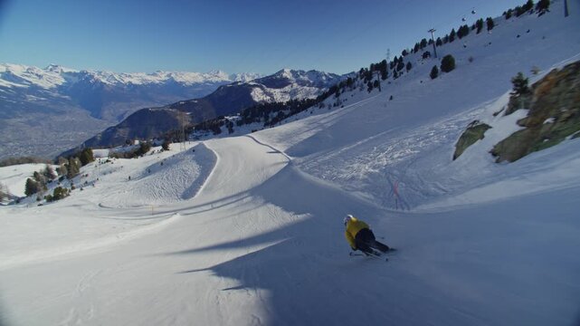 High performance alpine ski carving on groomed pistes in Verbier Bruson and Val de Bagnes filmed with drone and follow cam on a bluebird winter day showcasing fast dynamic fun skiing.