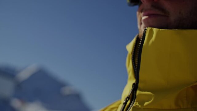 Close up footage of a skier zipping up a ski jacket before skiing at an alpine ski resort in the Verbier region Val de Bagnes Switzerland on a clear bluebird winter day
