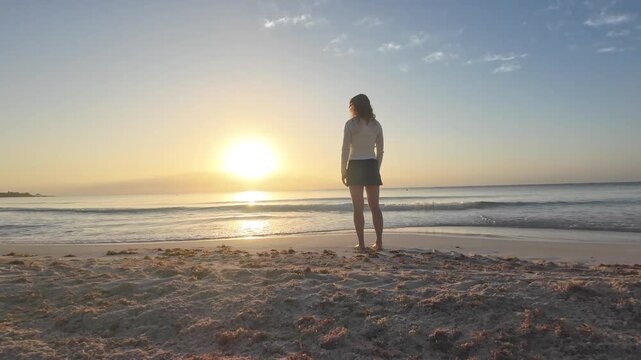 Woman walking and enjoying sunrise sunset on a calm Tulum beach. Mindfulness, wellness, gratitude, empowerment and tropical relaxation.