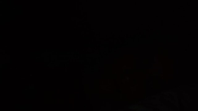 Thoughtful young woman lying in bed at night, scrolling on social media with a soft screen glow on her face, cinematic low light aesthetic.