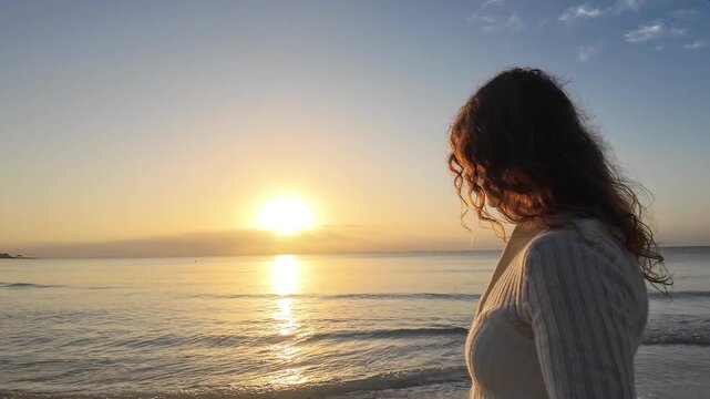 Woman walking and sitting on a cushion at sunrise on a Tulum beach. Mindfulness, wellness, and tropical relaxation.