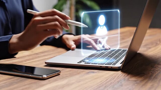 Young person using stylus and laptop with holographic user interface displaying profile icon and checkbox for verification dynamic digital technology concept