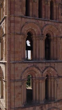 Romanesque bell tower of Iglesia de San Esteban, highlighting historic architecture and old town rooftops. Vertical Aerial Orbit