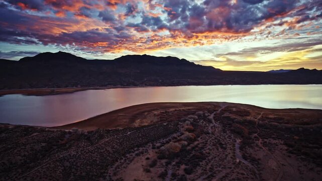 Cinematic drone perspective of sunrise sky glowing above Caballo Lake State Park in New Mexico.