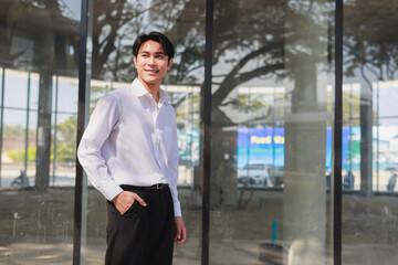 Fototapeta premium Young businessman smiling looking away in city
