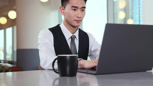 Businessman feeling tired and stressed when using laptop computer for remote work from office lobby or coffee shop, freelancer guy reading incoming emails, chatting online, researching studying online