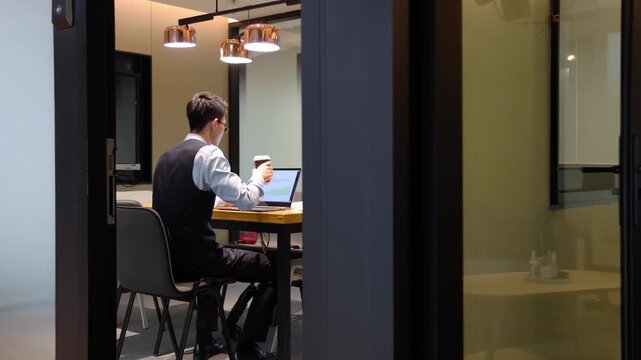 Focused busy young businessman working using laptop computer for remote work from office lobby or boardroom, freelancer guy reading incoming emails, chatting online, researching or studying online