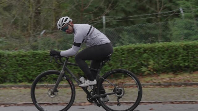 Side view of cyclist pedaling road bike in slow motion outdoors