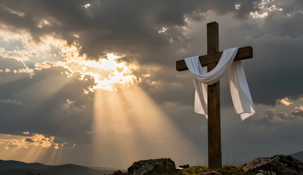 Wooden cross draped in cloth shines against a glowing cloudy backdrop