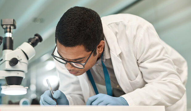 Man, scientist and writing notes in lab for research, medical report and experiment results. Male person, microscope and paperwork for record checklist, observation information and testing hypothesis
