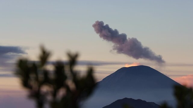Wide Shot of Sunrise Eruption of Mount Semeru Framed by Foreground Silhouettes from King Kong Hill in East Java , Indonesia