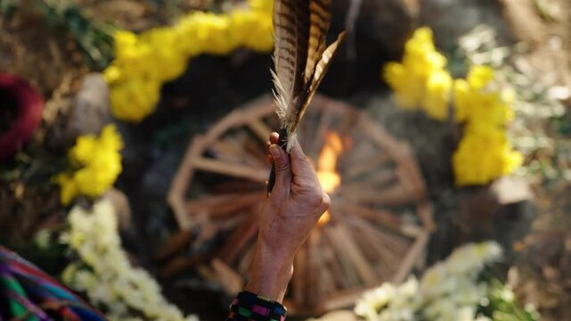 Feather raised over ceremonial fire during a traditional Mayan ritual