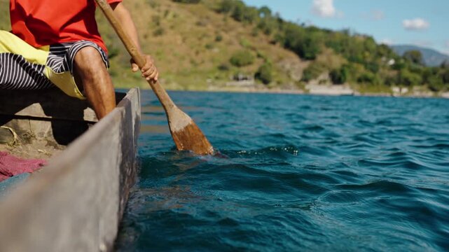 Close view of wooden paddle moving through Lake Atitl&aacute;n waters in Guatemala