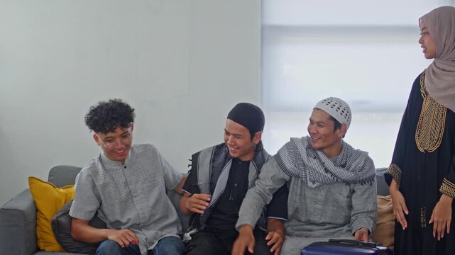 Young Asian Muslims chatting and laughing while preparing for Eid homecoming journey