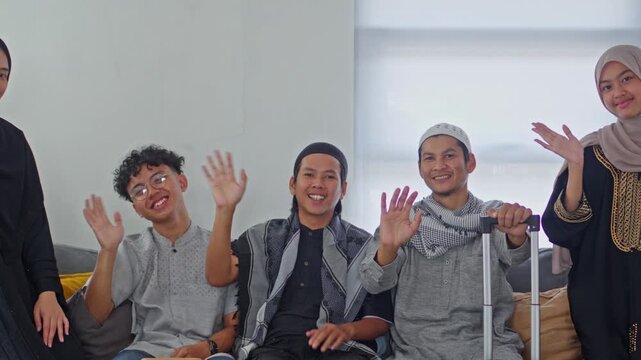 Group of young Indonesian family waving cheerfully while preparing for Mudik homecoming