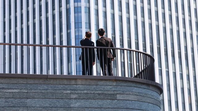 Business partners conversation with meeting outdoor for planning or discussion project on modern rooftop terrace, building real estate with client, developer for commercial investment on balcony