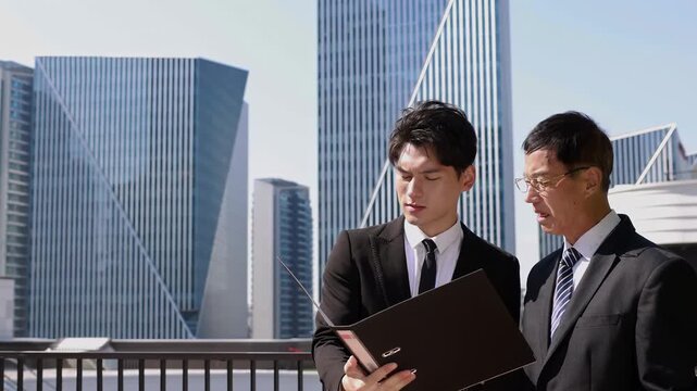 Two professional business partners meeting outdoor for planning or discussion project on modern rooftop terrace, Building city or real estate with client developer management for commercial investment