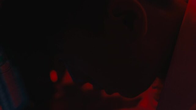 A cinematic and atmospheric close-up of a trader's face, heavily illuminated by red light, capturing a moment of profound disappointment and stress during a financial crisis