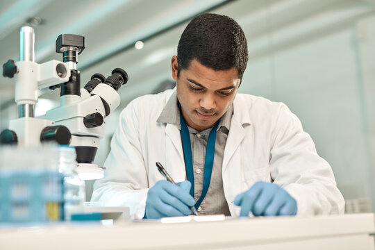 Man, scientist and writing on paperwork in lab for research, medical report and experiment results. Male person, microscope and documents for checklist, observation information and testing hypothesis