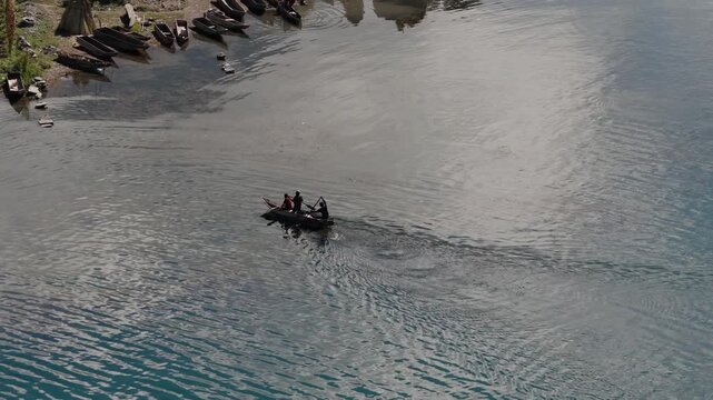 Aerial view of fishermen rowing a wooden boat across Lake Atitlan Guatemala