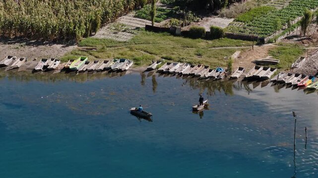 Aerial view of fishermen working near lined wooden canoes on Lake Atitlan Guatemala