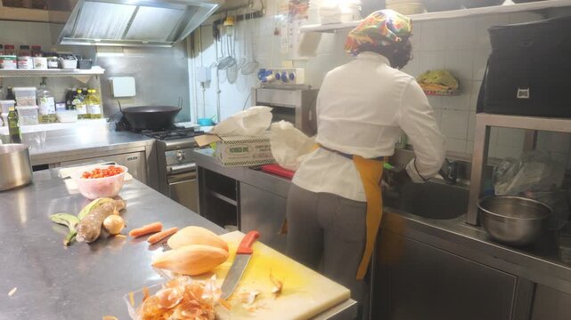 African women chefs cooking together in professional kitchen with cassava, yam and vegetable prep