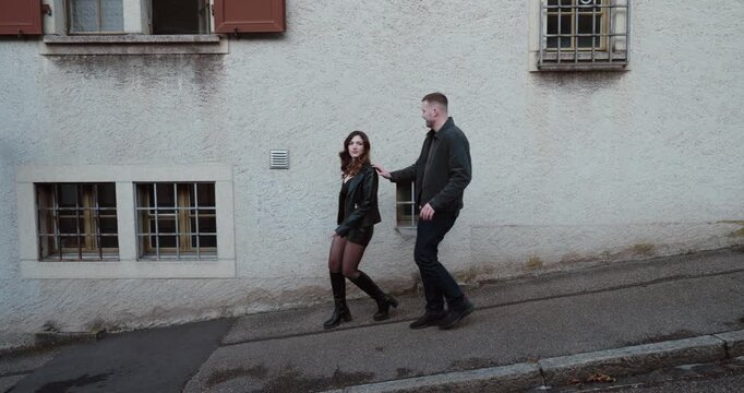 Outdoor scene of a man approaching a woman on the street and being rejected as she walks away. Concept of social rejection, dating failure, awkward interaction and emotional response.