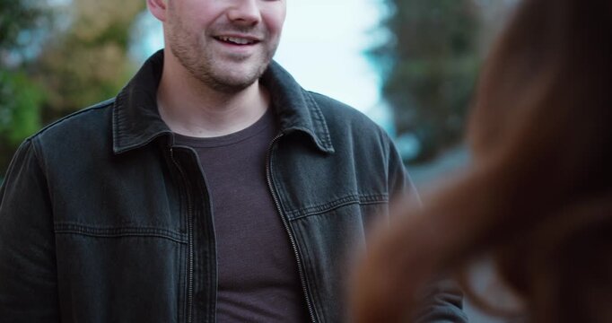 Outdoor scene of a man approaching and speaking to a woman from behind on a quiet street. Concept of social interaction, unexpected conversation, dating attempt and relationship dynamics.