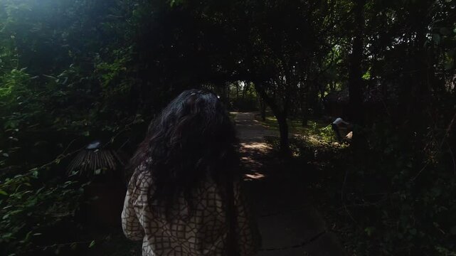 Indian Woman casually walking inside a luxury, eco-conscious, forest resort in Nagarahole, slow motion