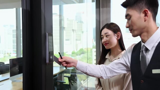 Businessman in a suit swiping electronic cards reader to enter the office through a automatic security, leading clients on a tour and introduction about company