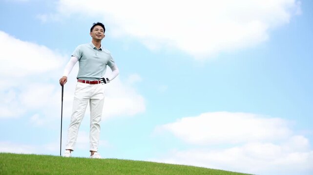 Golfer Male Golf Sport Athlete Holding a Golf Club Gazing into the Distance Walking on a field playing golf for fitness, workout or exercise enjoying vacation luxury resort using driver on a sunny day