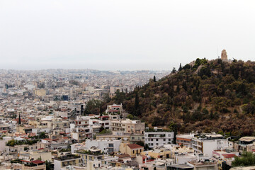 Obraz premium Panoramic View Toward Philopappos Monument August 2024 Urban buildings and historic hill Athens