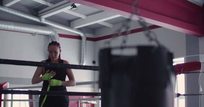 This video shows a woman boxer taking the essential step of hand wrapping with care, setting the foundation for a safe and effective rigorous boxing training session.