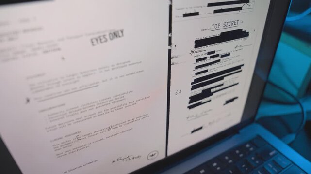 Various classified top secret confidential files appear on laptop screen in dark room in office or home. Security breach stealing sensitive documents or exposing spy surveillance or access to server