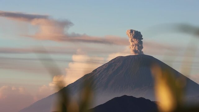 Wide shot of Sunrise Eruption of Mount Semeru Framed by Foreground Silhouettes from King Kong Hill in East Java , Indonesia