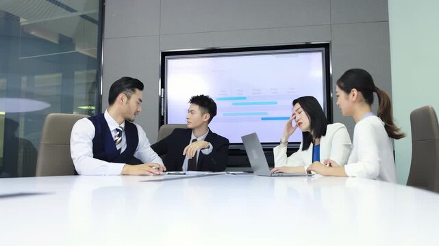 Frustrated businessman CEO in formal suit feeling headache stress, sitting silently and spectating. Group of people coworkers team arguing during important meeting to discuss and resolve difficulties