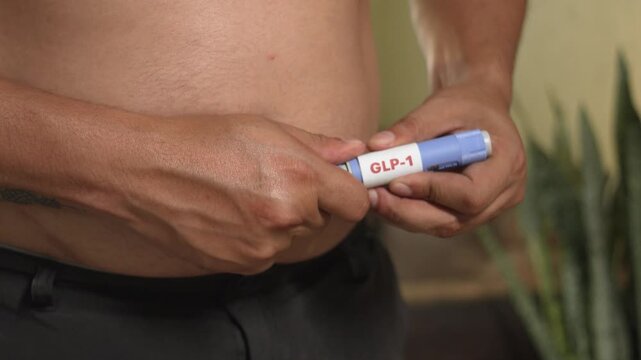 Overweight man holding GLP-1 injection pen (semaglutide) for weight management, metabolic health