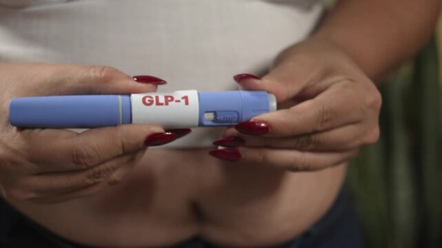 Close-up of woman holding GLP-1 injection pen (semaglutide) before self-injection, obesity treatment