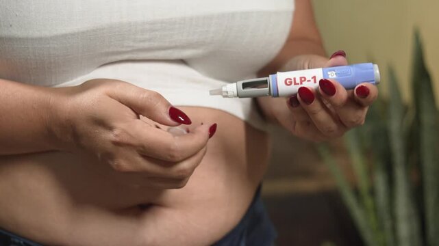 Overweight woman preparing GLP-1 agonist injection pen (semaglutide) for weight management