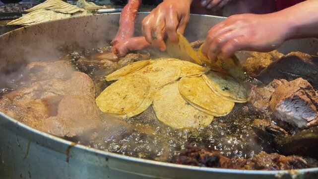 Close-up of traditional Mexican suadero and longanisa meats sizzling on a professional street food griddle in Mexico City. Authentic culinary action