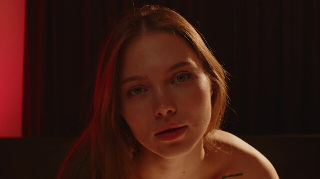 Beautiful portrait of an attractive woman sensually posing while enticingly looking at the camera with her deep blue eyes