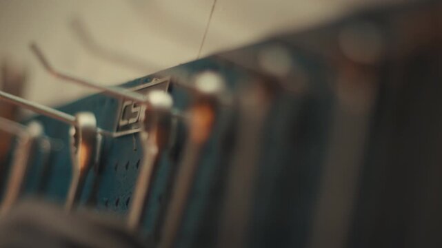 Close up of organized wrenches hanging on workshop tool rack, rack focus along pegboard wall following mechanic hands