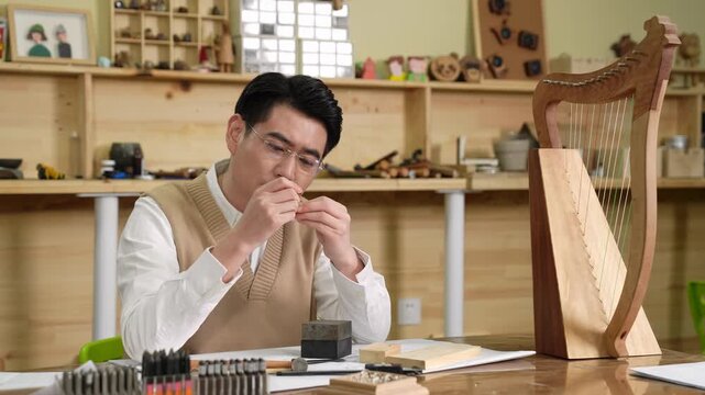 Carefully handling craftsman skilled jewelry maker crafting a silver ring to check specifications at rustic wooden workbench with precision tools. Expert craftsman works on detailed metal accessory