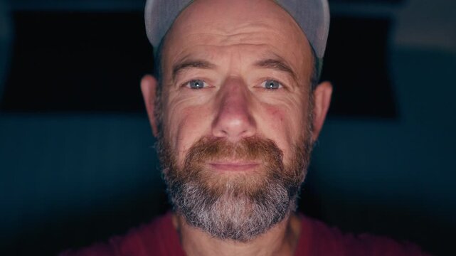 Frontal view on illuminated face of man in his forties making direct eye contact